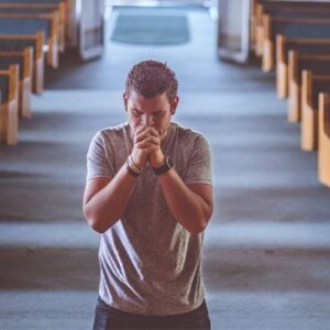 homem orando na igreja de joelho